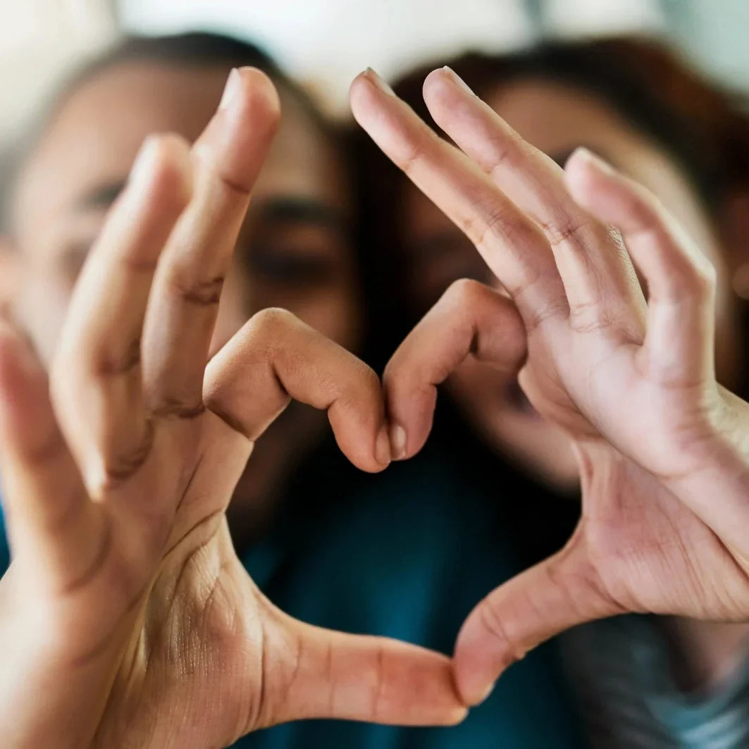 Couple in love making a heart shape with their hands.